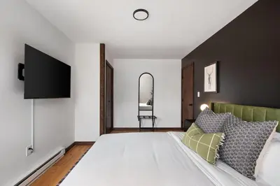 a bedroom with a large white bed and a tv at Cozy Poconos Retreat - pool table, hot tub, fire pit in Tobyhanna