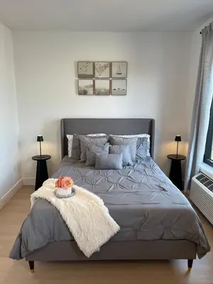 a bedroom with a bed with a blanket and pillows at Luxury Queen Studio- Minutes To NYC, EWR & MetLife in Elizabeth