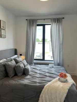 a bedroom with a large bed with a window at Luxury Queen Studio- Minutes To NYC, EWR & MetLife in Elizabeth
