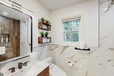 a white bathroom with a sink and a mirror at Blue Mountain Crossing in East Stroudsburg
