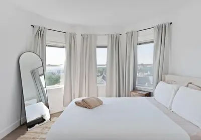 a bedroom with a white bed and a large window at Nyc skyline view, 17m- Manhattan, Prime location in Carlstadt