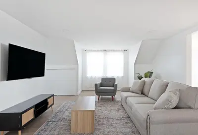 a living room with a couch and a flat screen tv at Nyc skyline view, 17m- Manhattan, Prime location in Carlstadt