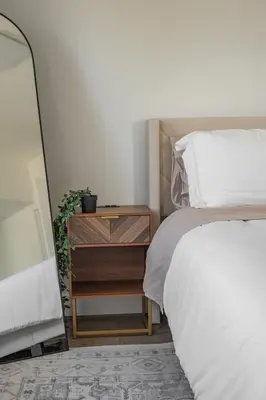 a bedroom with a bed and a wooden night stand at Nyc skyline view, 17m- Manhattan, Prime location in Carlstadt