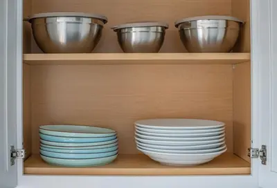 a cupboard with bowls and plates in it at Nyc skyline view, 17m- Manhattan, Prime location in Carlstadt