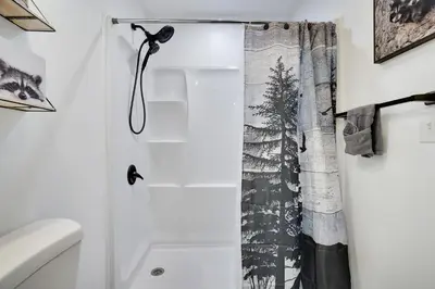 a bathroom with a shower with a shower curtain at Cozy 2BR Townhouse with Mountain Views & BBQ in Lake Harmony