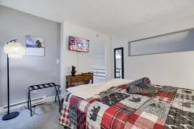 a bedroom with a bed with a quilt on it at Cozy 2BR Townhouse with Mountain Views & BBQ in Lake Harmony