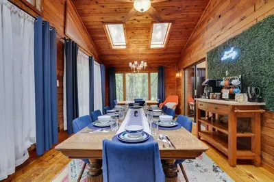 a dining room with a long table and blue chairs at Gloria's Hot Tub Game Room Fire Pit in Blakeslee