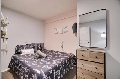 a bedroom with a bed and a dresser with a mirror at Gloria's Hot Tub Game Room Fire Pit in Blakeslee