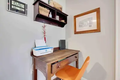 a desk in a room with a orange chair at Gloria's Hot Tub Game Room Fire Pit in Blakeslee
