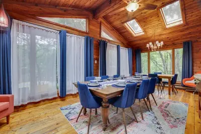 a dining room with a long table and blue chairs at Gloria's Hot Tub Game Room Fire Pit in Blakeslee
