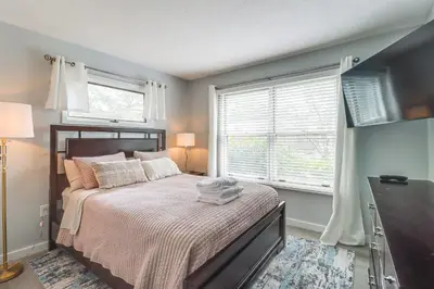 a bedroom with a bed and two windows at Family Gem with Deck Across From Shawnee Mountain! in East Stroudsburg