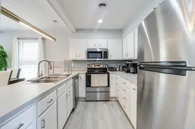 a kitchen with white cabinets and stainless steel appliances at Family Gem with Deck Across From Shawnee Mountain! in East Stroudsburg