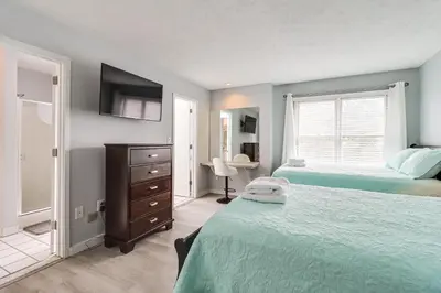 a bedroom with two beds and a dresser and a window at Family Gem with Deck Across From Shawnee Mountain! in East Stroudsburg