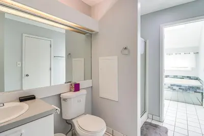 a white bathroom with a toilet and a sink at Family Gem with Deck Across From Shawnee Mountain! in East Stroudsburg