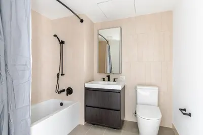 a bathroom with a sink and a toilet and a bath tub at Blueground Alphabet City rooftop nr Tompkins Square Park NYC-2057 in New York