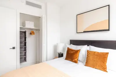 a bedroom with a bed with orange pillows at Blueground Alphabet City rooftop nr Tompkins Square Park NYC-2057 in New York