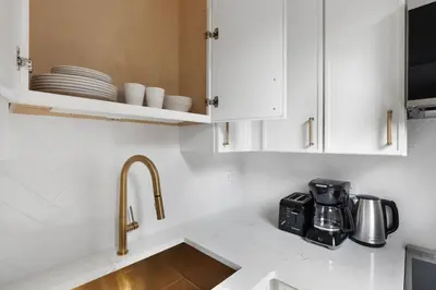 a kitchen with white cabinets and a sink at Blueground Lincoln Square view nr Central Park NYC-2065 in New York