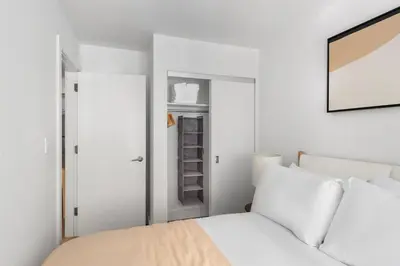 a white bedroom with a bed and a closet at Blueground Midtown East rooftop nr Grand Central NYC-2069 in New York