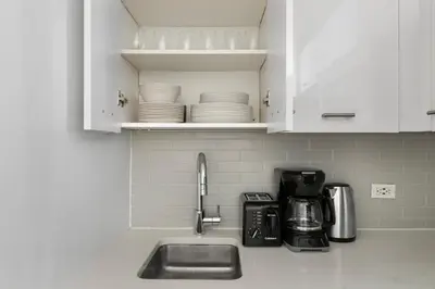 a kitchen counter with a sink and a microwave at Blueground Midtown East rooftop nr Grand Central NYC-2069 in New York