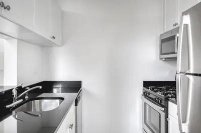 a kitchen with a sink and a stove at Blueground Lincoln Square fitness center nr Riverside Park NYC-846 in New York