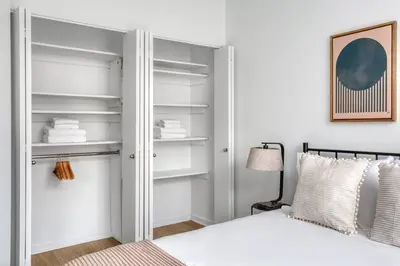 a bedroom with a white bed and white shelves at Blueground Lincoln Square fitness center nr Riverside Park NYC-846 in New York