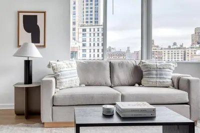 a living room with a couch and a large window at Blueground Lincoln Square fitness center nr Riverside Park NYC-846 in New York