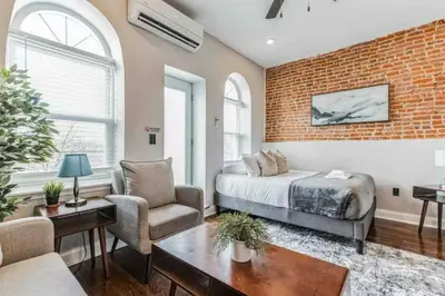 a bedroom with a bed and a brick wall at Studio w Terrace - Street Parking -10 min to DT in Philadelphia