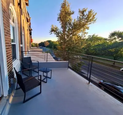 a balcony with two chairs and a table on a building at Studio w Terrace - Street Parking -10 min to DT in Philadelphia