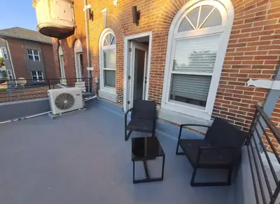 a patio with two chairs and a heater on a building at Studio w Terrace - Street Parking -10 min to DT in Philadelphia