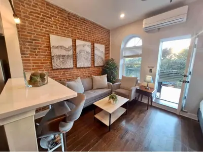 a living room with a couch and a brick wall at Studio w Terrace - Street Parking -10 min to DT in Philadelphia