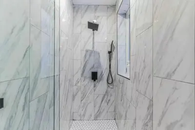 a bathroom with a shower with a glass door at Studio w Terrace - Street Parking -10 min to DT in Philadelphia