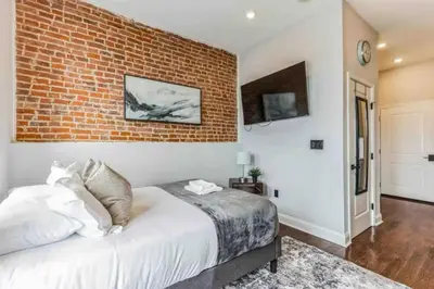 a bedroom with a brick wall and a bed at Studio w Terrace - Street Parking -10 min to DT in Philadelphia