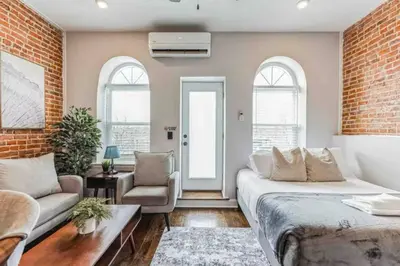 a room with a bed and a couch and a brick wall at Studio w Terrace - Street Parking -10 min to DT in Philadelphia
