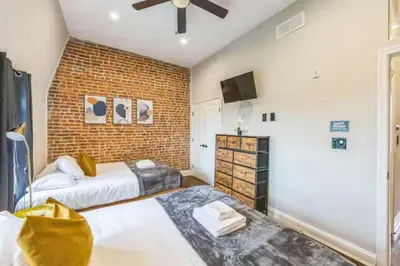 a bedroom with two beds and a brick wall at Lovely 2BR w Patio - 10 mins to DT - Sleeps 10 in Philadelphia