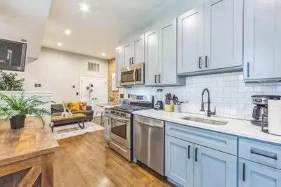 a kitchen with white cabinets and a sink at Lovely 2BR w Patio - 10 mins to DT - Sleeps 10 in Philadelphia
