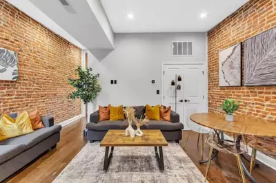 a living room with couches and a brick wall at Lovely 2BR w Patio - 10 mins to DT - Sleeps 10 in Philadelphia