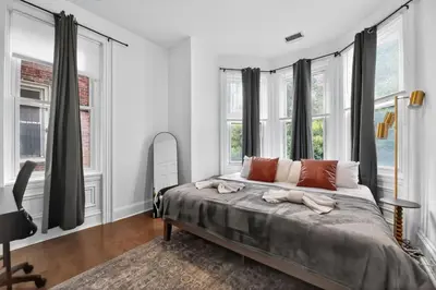 a bedroom with a large bed with windows at Lovely 1BR Center City with King Bed and Sleeper Sofa in Philadelphia