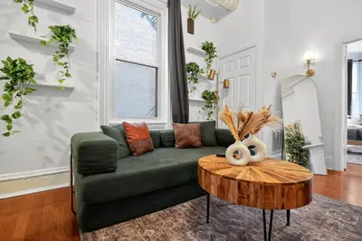 a living room with a green couch and a wooden table at Lovely 1BR Center City with King Bed and Sleeper Sofa in Philadelphia