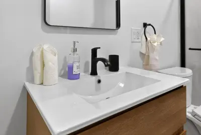a bathroom with a white sink and a mirror at Lovely 1BR Center City with King Bed and Sleeper Sofa in Philadelphia