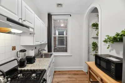a kitchen with white cabinets and a stove top oven at Lovely 1BR Center City with King Bed and Sleeper Sofa in Philadelphia