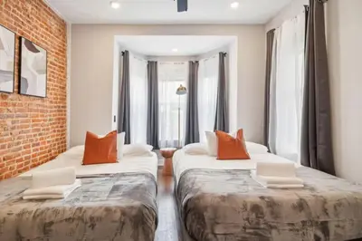 two beds in a room with a brick wall at Jr 1Br w 2 Beds - Sleeps 4 - 10 min to DT in Philadelphia