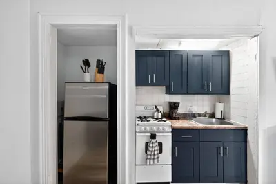 a kitchen with blue cabinets and a white refrigerator at Perfect Cozy Studio in Center City with Fast WiFi in Philadelphia