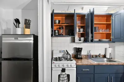 a kitchen with a stove and a sink and blue cabinets at Perfect Cozy Studio in Center City with Fast WiFi in Philadelphia
