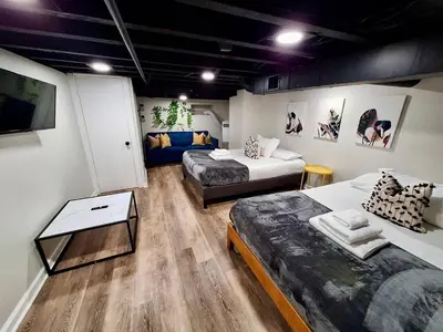 a room with two beds and a couch and a table at Bi-Level 3 BR plus Finished Basement that Sleeps 12 in Philadelphia