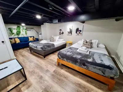 a room with two beds and a couch in it at Bi-Level 3 BR plus Finished Basement that Sleeps 12 in Philadelphia