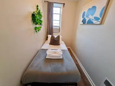 a small room with a bed and a window at Bi-Level 3 BR plus Finished Basement that Sleeps 12 in Philadelphia