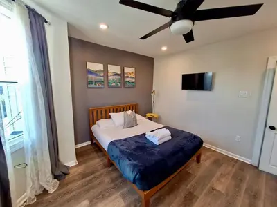 a bedroom with a bed with a ceiling fan at Bi-Level 3 BR plus Finished Basement that Sleeps 12 in Philadelphia