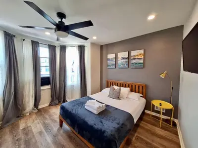 a bedroom with a bed with a ceiling fan at Bi-Level 3 BR plus Finished Basement that Sleeps 12 in Philadelphia