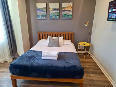 a bedroom with a large bed with a blue blanket at Bi-Level 3 BR plus Finished Basement that Sleeps 12 in Philadelphia