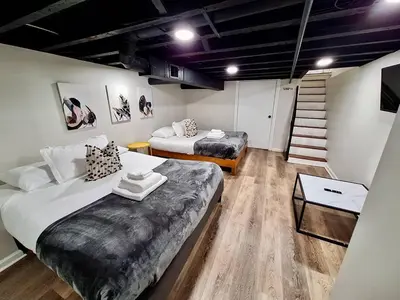 a room with two beds and a staircase in it at Bi-Level 3 BR plus Finished Basement that Sleeps 12 in Philadelphia